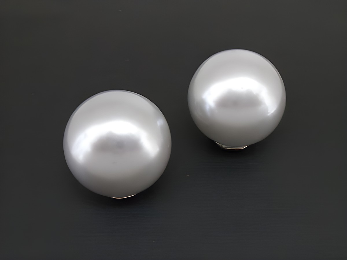 Graue, zeitlose Ohrclips aus silberfarbenem Material mit synthetischen Zuchtperlen, hergestellt von Juwelier Harnisch. Ideal für eleganten Schmuck.