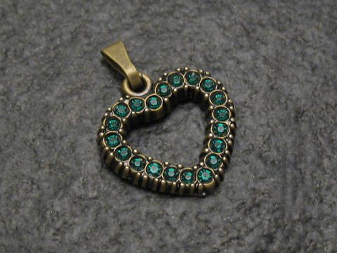 Grüner Strass Anhänger mit sexy City Look in Herzform, umrahmt von glänzenden Strasssteinen, hergestellt von Juwelier Harnisch, ideal als modisches Accessoire.