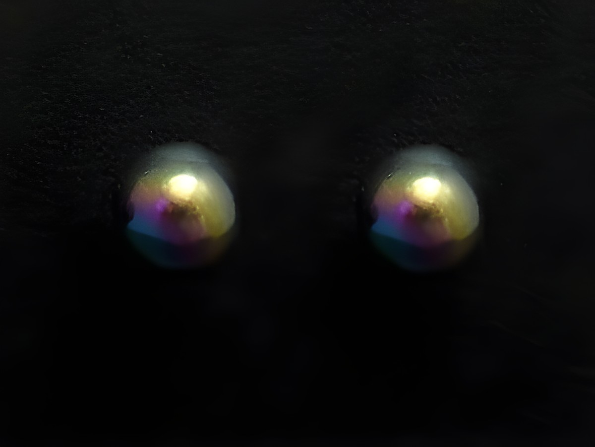 Bunte Ohrstecker aus Edelstahl mit einem Durchmesser von 4 mm, hergestellt von Juwelier Harnisch, mit schimmernder rainbow Oberfläche.