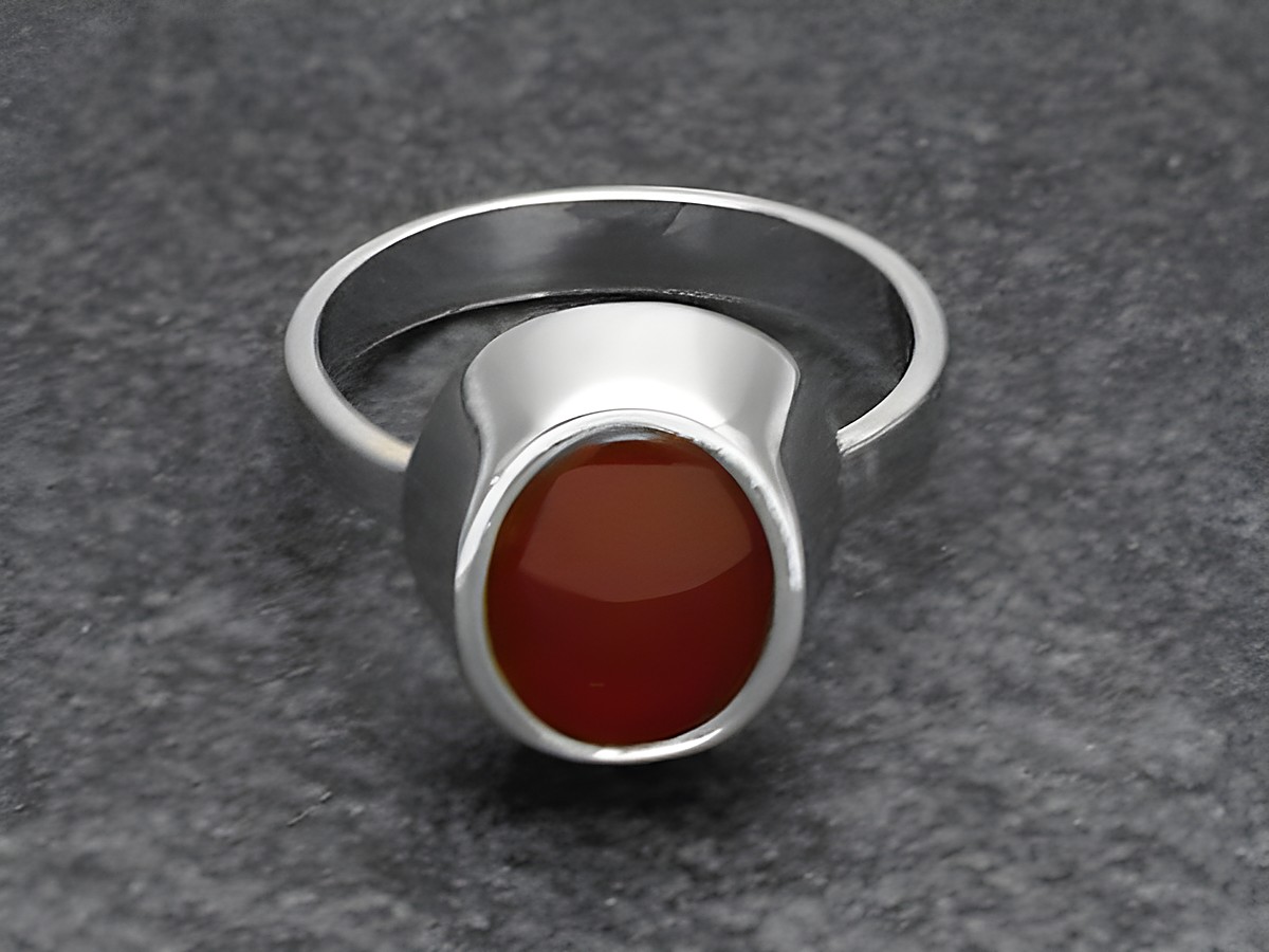 Silberring mit verstellbarem Band und rhodiniertem Stein aus Karneol, hergestellt von Juwelier Harnisch, klassisches Design.