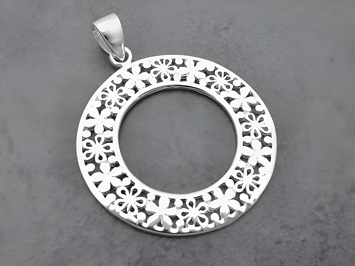 Runder Silber Anhänger mit floralen Muster, hergestellt von Juwelier Harnisch, zeigt filigrane Motive und eine klare Mitte für persönlichen Ausdruck.