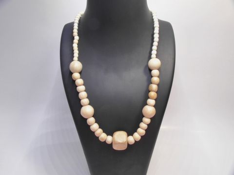 Holzkette aus naturbraunen Holzperlen in verschiedenen Größen, 18 mm dick, 60 cm lang, gefertigt vom Juwelier Harnisch, präsentiert auf einem schwarzen Schmuckständer.