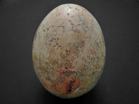 Ein sandfarben-buntes Steinei aus Achat, gefertigt aus Naturstein, Maße 63,8 x 46,7 x 46,7 mm, mit einzigartiger Musterung und Oberfläche, Hersteller Juwelier Harnisch.