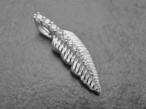Ein eleganter Anhänger in Form eines Blattes aus Sterling Silber, verziert mit weißen Zirkonia, hergestellt von Juwelier Harnisch, symbolisiert Natur und Eleganz.