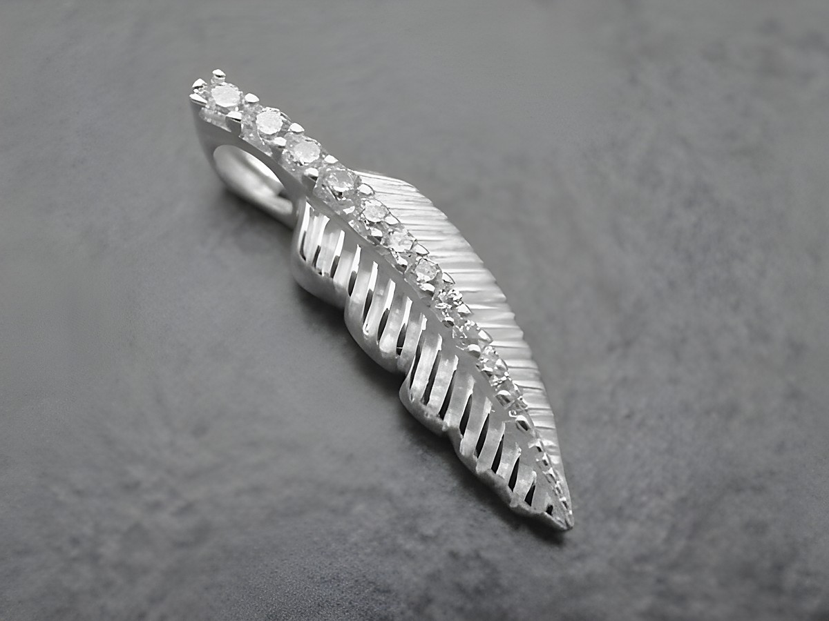 Ein eleganter Anhänger in Form eines Blattes aus Sterling Silber, verziert mit weißen Zirkonia, hergestellt von Juwelier Harnisch, symbolisiert Natur und Eleganz.