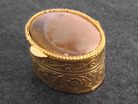 Multifunktionale Dose aus goldfarbenem Metall mit ovalem braunem Achat Stein, Hersteller Juwelier Harnisch, kunstvoll verziert und geschlossen. Ideal für Schmuck oder kleine Utensilien.