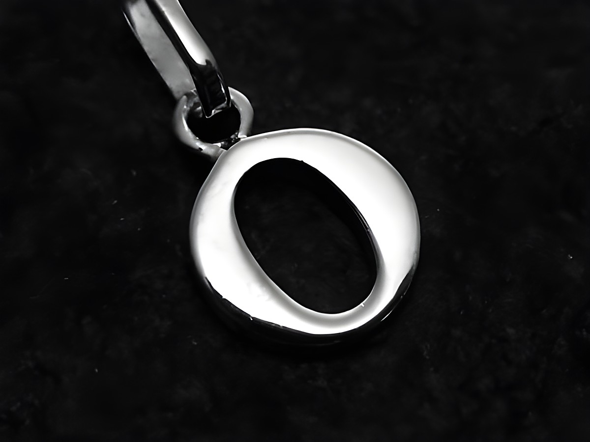 O-Buchstaben Anhänger aus Weißgold 585, gefertigt von Juwelier Harnisch, zeigt den Buchstaben O in schlanker, eleganter Form auf schwarzem Hintergrund.