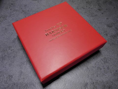 Viereckige rote Geschenkbox mit schwarzem Innenfutter, Hersteller Juwelier Harnisch, Maße 80 x 80 x 24 mm, ideal für Schmuckstücke.