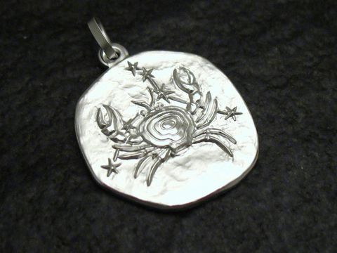 Sternzeichen Anhänger Krebs aus Sterling Silber, gefertigt von Juwelier Harnisch, zeigt einen stilisierten Krebs mit Sternen auf einer ovalen Plakette.