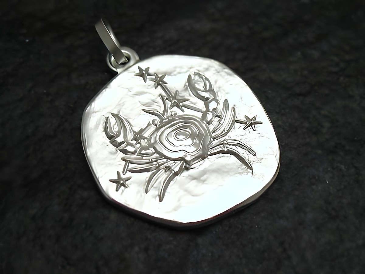 Sternzeichen Anhänger Krebs aus Sterling Silber, gefertigt von Juwelier Harnisch, zeigt einen stilisierten Krebs mit Sternen auf einer ovalen Plakette.