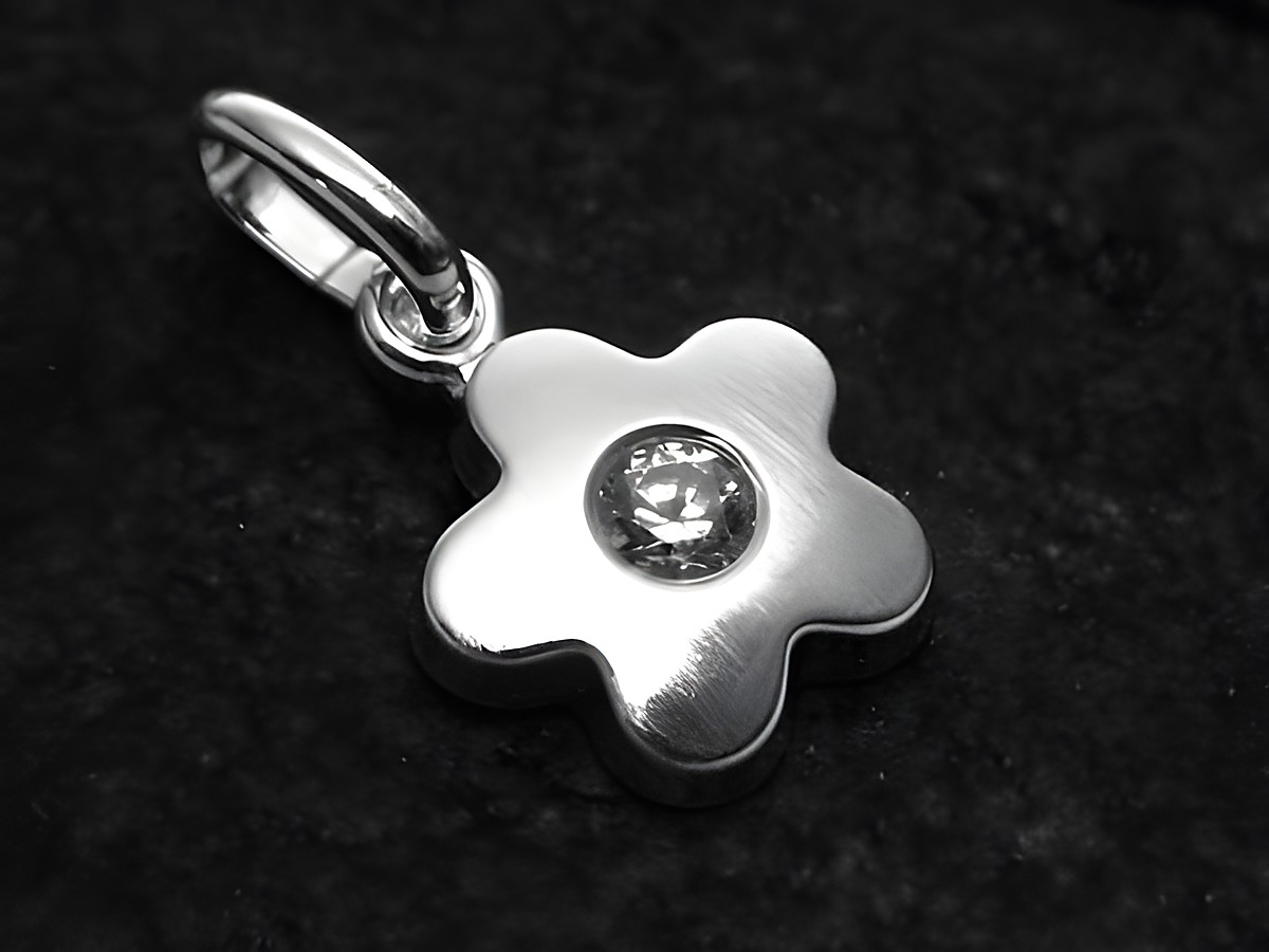 Blümchen mattierter Sterling Silber Anhänger mit Zirkonia, hergestellt von Juwelier Harnisch. Der Anhänger hat eine blumenförmige Gestaltung und ist mittig mit einem glitzernden Zirkonia verziert.