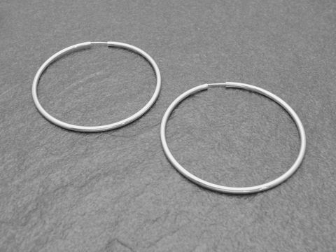 Silber Creolen 5 cm aus Sterling Silber mit einem Durchmesser von 45 mm und einer Stärke von 2,5 mm, präsentiert auf einem grauen Untergrund.