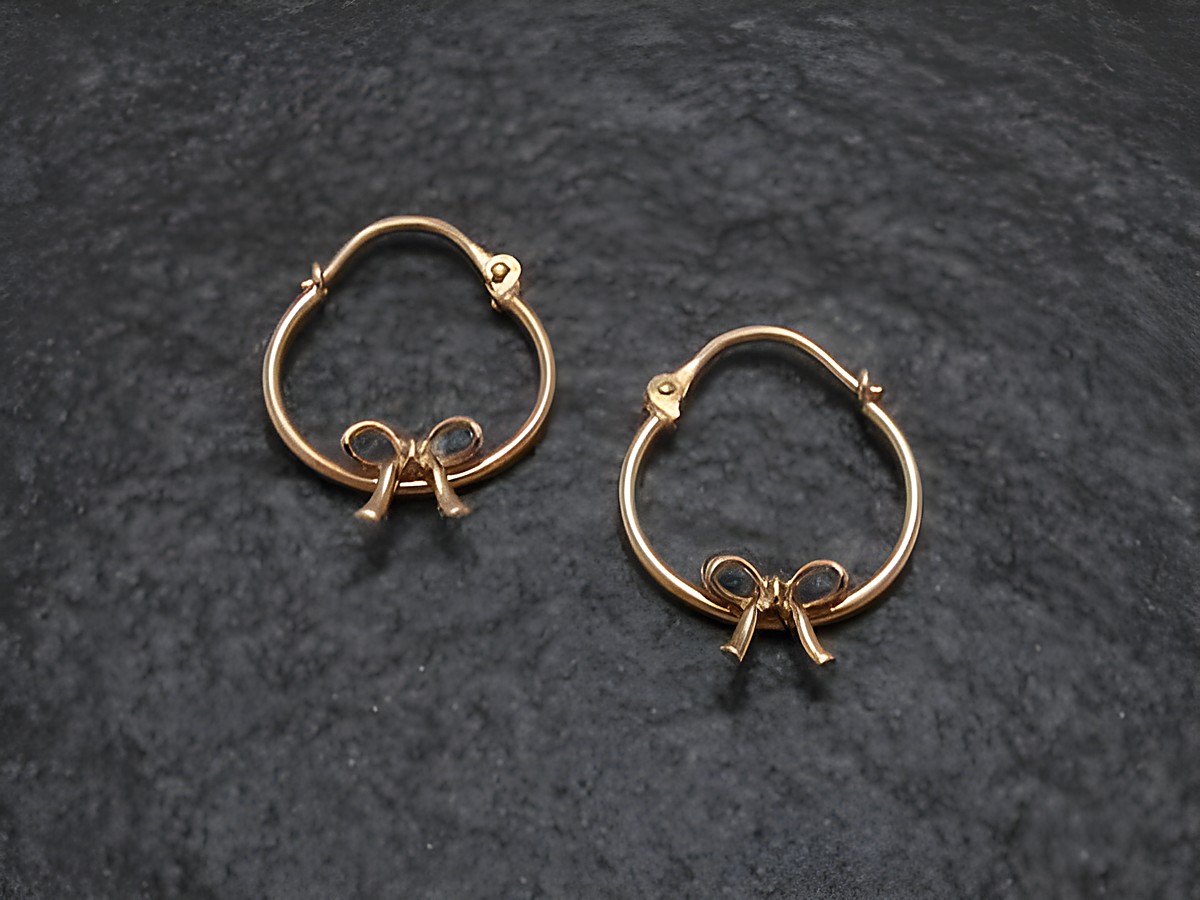 Creole aus Gold mit Schleife als Kinderschmuck, Hersteller Juwelier Harnisch, Durchmesser bis 15 mm. Feine Verarbeitung und elegantes Design, ideal für kleine Ohrlöcher.