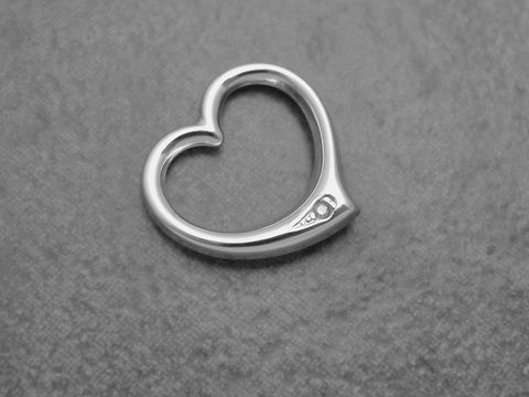 Herzanhänger aus rhodiniertem Sterling Silber mit durchlaufendem Design und einem Diamanten. Hersteller Juwelier Harnisch, schlichter und eleganter Schmuck für jeden Anlass.