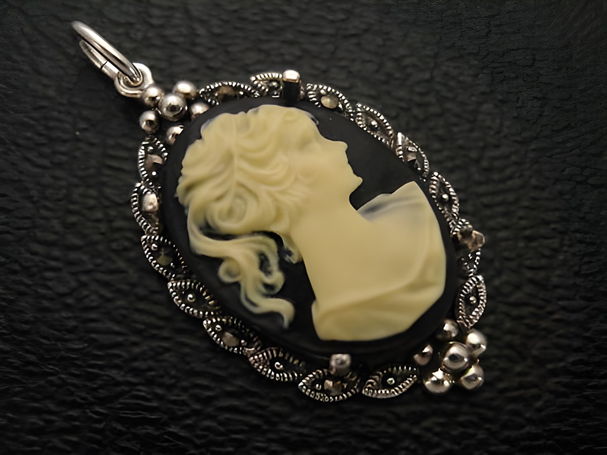 Cabochon Kunstharzgemme in Schwarz mit Silber-Medaillon Anhänger, zeigt das Profil einer stilisierten Dame in hellem Farbton, ideal als elegantes Schmuckstück. Hersteller Juwelier Harnisch.
