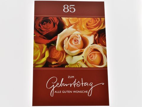 Geburtstagskarte mit farbenfrohen Rosenblüten in verschiedenen Nuancen, darunter rote und gelbe Rosen, mit dem Text zum Geburtstag alle guten Wünsche und der Zahl 85, Hersteller Juwelier Harnisch.