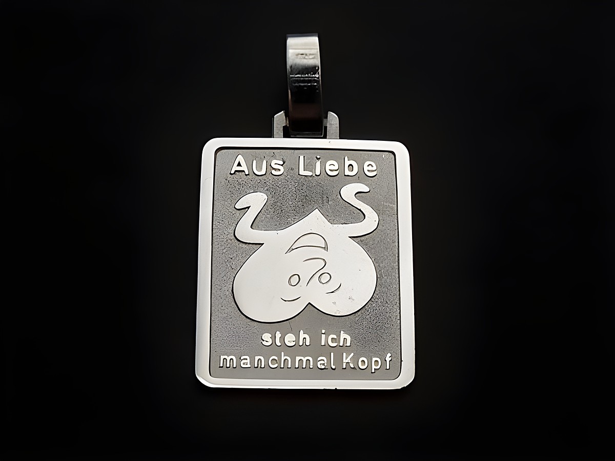 Silber Anhänger mit dem Schriftzug Aus Liebe steh ich manchmal Kopf und einem humorvollen Motiv, hergestellt von Juwelier Harnisch, ideal für besondere Anlässe.