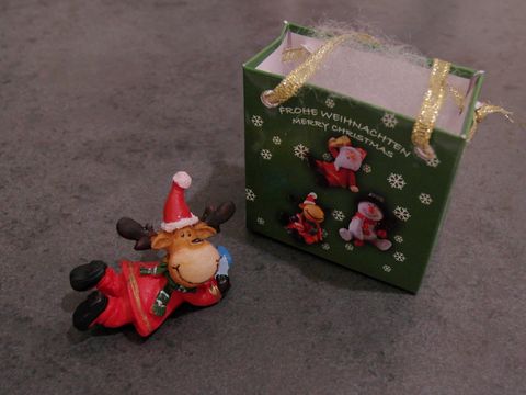 Elch-Rentier mit Geschenktasche liegend mit Geschenk, Hersteller Juwelier Harnisch, perfekt für Weihnachten. Das dekorative Element bringt festliche Stimmung in jeden Raum.