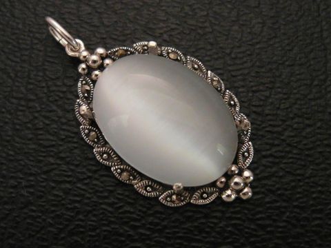 Cabochon Katzenauge weiß in einem Silber Medaillon Anhänger, Hersteller Juwelier Harnisch, elegant und filigran verarbeitet, ideal als Schmuckstück.