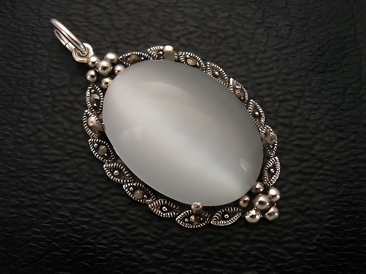Cabochon Katzenauge weiß in einem Silber Medaillon Anhänger, Hersteller Juwelier Harnisch, elegant und filigran verarbeitet, ideal als Schmuckstück.