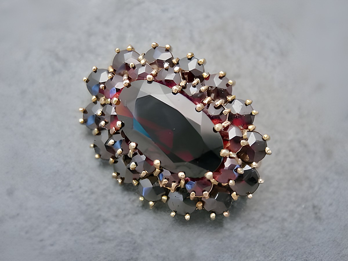 Granat Schmuck Brosche 29,2 mm oval in Gold mit funkelnden Granatsteinen, designet vom Juwelier Harnisch, elegante und zeitlose Brosche für jeden Anlass.