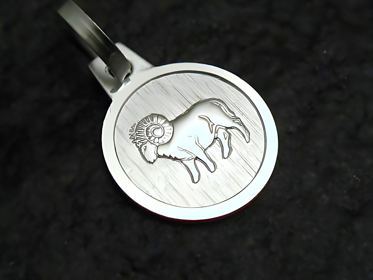 Widder Sternzeichen Anhänger aus Sterling Silber, gefertigt von Juwelier Harnisch, zeigt kunstvoll gravierten Widder auf einer matten Oberfläche, ideal für astrologische Schmuckliebhaber.
