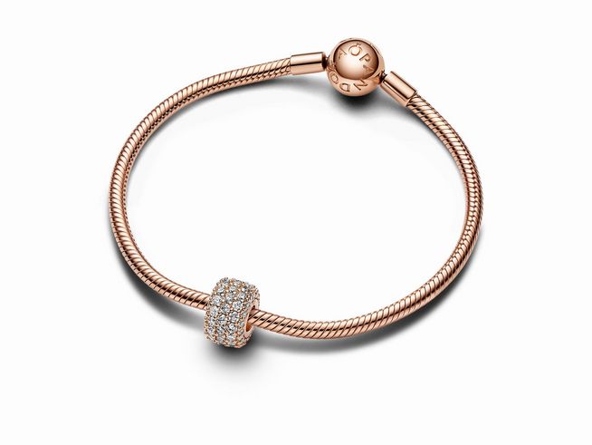 Funkelndes dreireihiges Pavé-Charm von Pandora in Roségold Vergoldung, verziert mit Zirkonia, eingebettet in ein elegantes Armband mit Klemmsystem.