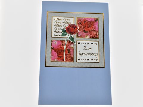Geburtstagskarte mit Roseblüten, hellblauer Hintergrund, goldene Umrandung, Aufschrift "Zum Geburtstag" und vier Bildern von rosanen und roten Rosen, Hersteller Juwelier Harnisch.