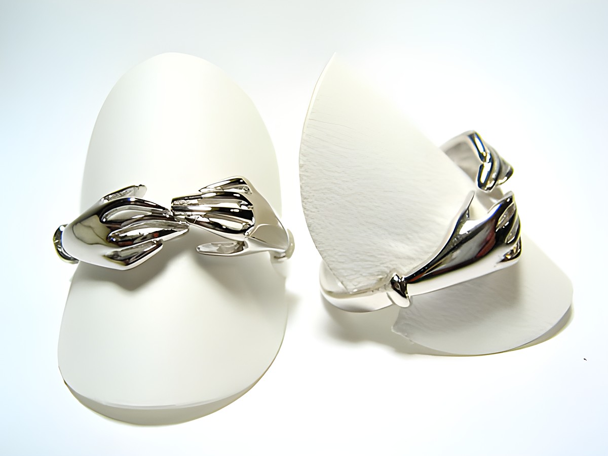 Silber Ring rhodiniert mit zwei Hände-Motiven, größenverstellbar, Hersteller: Juwelier Harnisch, ohne Stein, auf weißen Ringauffangern präsentiert.