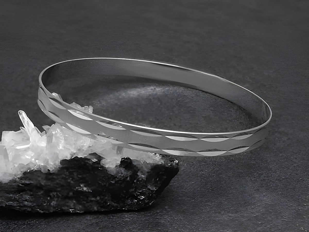 Silber Armreifen gestrichelt 6,4 mm rhodiniert 20,5 cm von Juwelier Harnisch auf schwarzem Hintergrund, elegant und zeitlos, ideal für jeden Anlass.