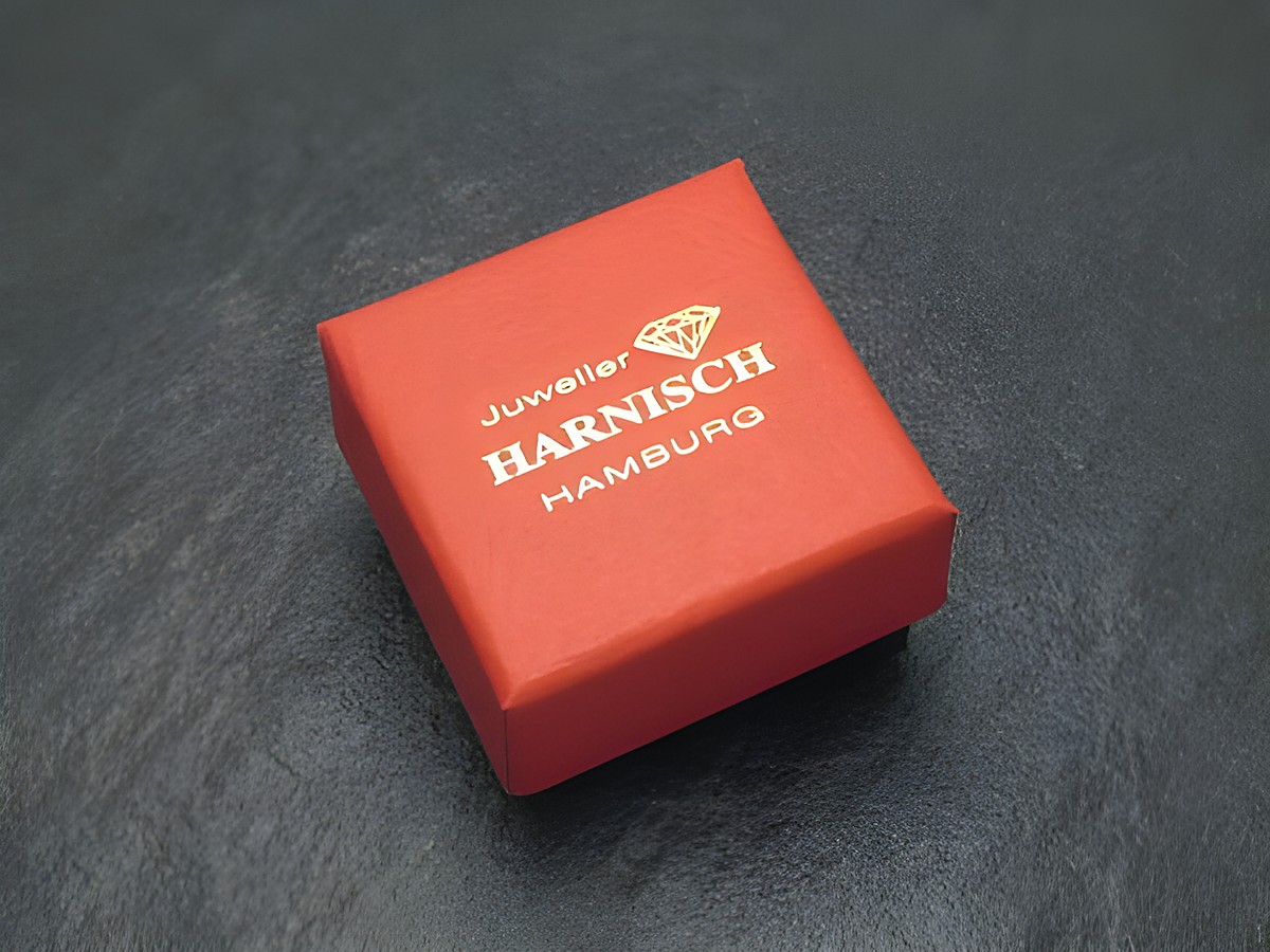 Geschenkbox 4 cm - rot schwarz - elegant, Hersteller: Juwelier Harnisch, Geschenkbox. Die Box ist rot mit goldener Schrift und einem Diamanten-Logo. Ideal für Schmuckpräsentationen. – Ansicht 2