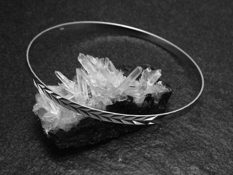 Silber Armreifen im 70er Design, rhodiniert, 3,5 mm dick und 21 cm lang, von Juwelier Harnisch, auf Kristallbasis präsentiert, betont durch einen eleganten und zeitlosen Stil.