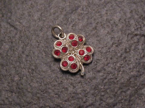 Roter Strass Anhänger in Form eines Kleeblatts, glänzende rote Steine, feine Silver-Optik, ideal für einen sexy City Look, Hersteller Juwelier Harnisch, weitere Formen erhältlich.