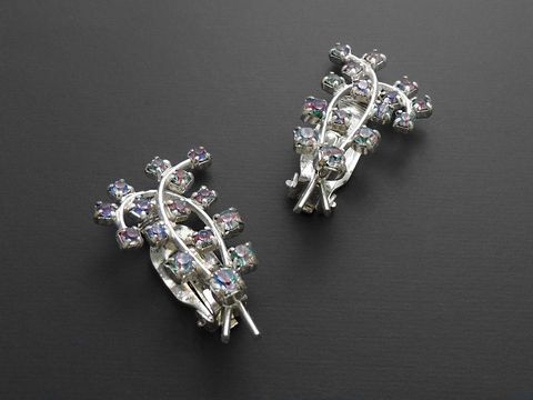 Strass Ohrclip in elegantem Design, bunt schimmernde Steine in einer geschwungenen Form, hergestellt von Juwelier Harnisch, ideal für besondere Anlässe und stilvolle Auftritte.