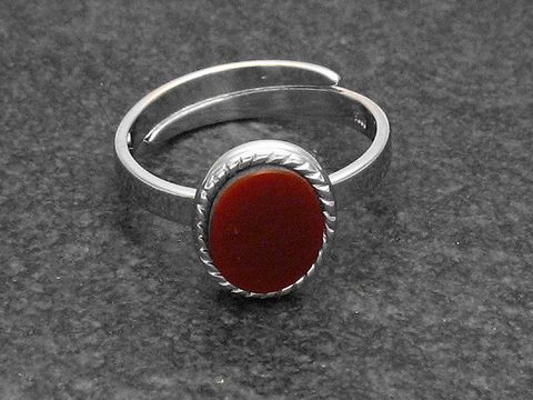 Silberring mit ovaler, gearbeiteter Fassung und Karneolstein, größenverstellbar, hergestellt von Juwelier Harnisch, mit rhodiniertem Finish.