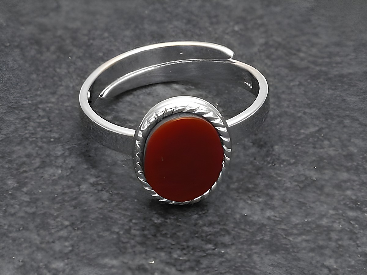 Silberring mit ovaler, gearbeiteter Fassung und Karneolstein, größenverstellbar, hergestellt von Juwelier Harnisch, mit rhodiniertem Finish.