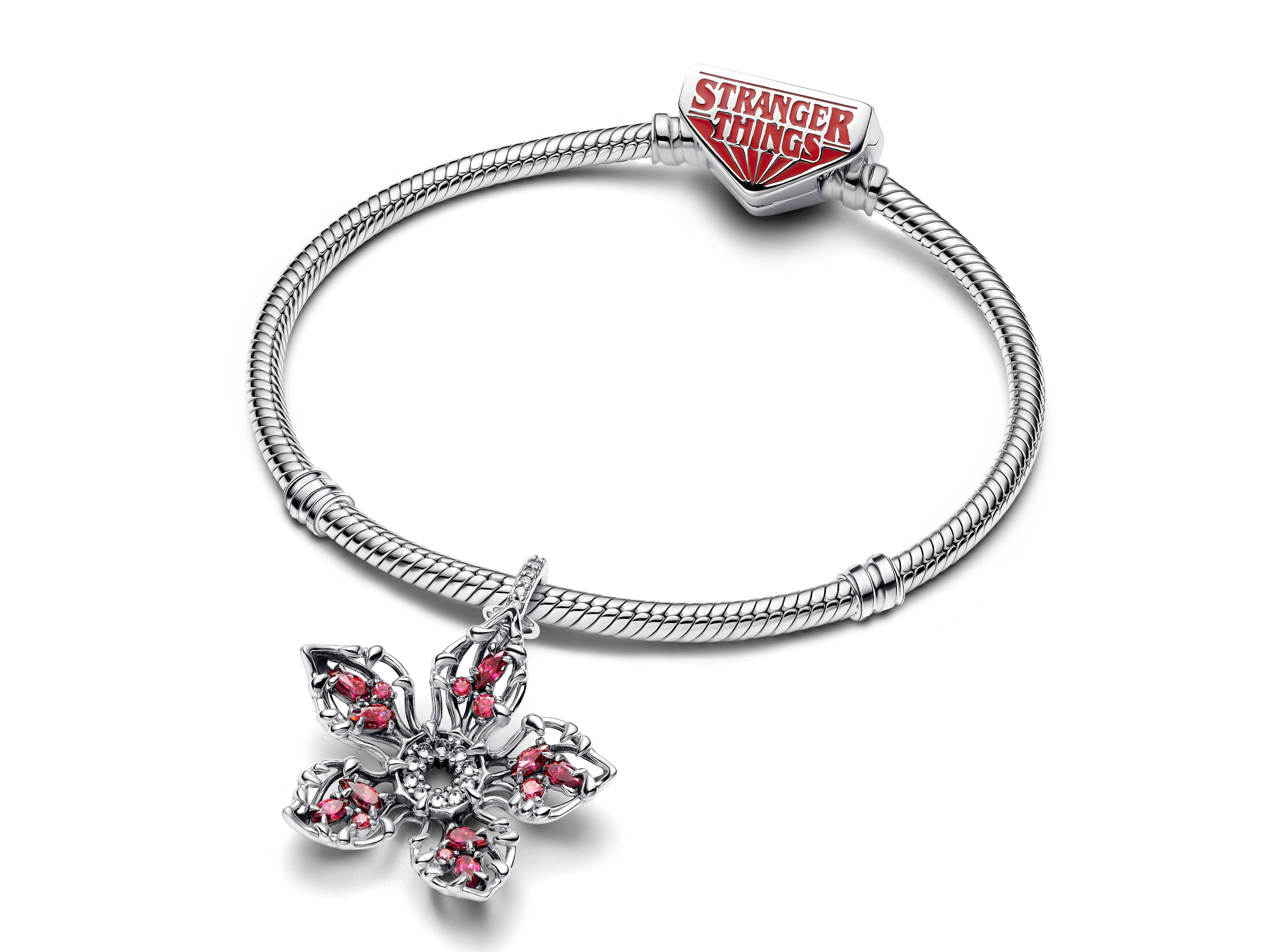 Pandora Charm aus Silber mit einem blühenden Anhänger, verziert mit rotem und klarem Zirkonia, ergänzt durch einen charakteristischen Stranger Things Verschluss.
