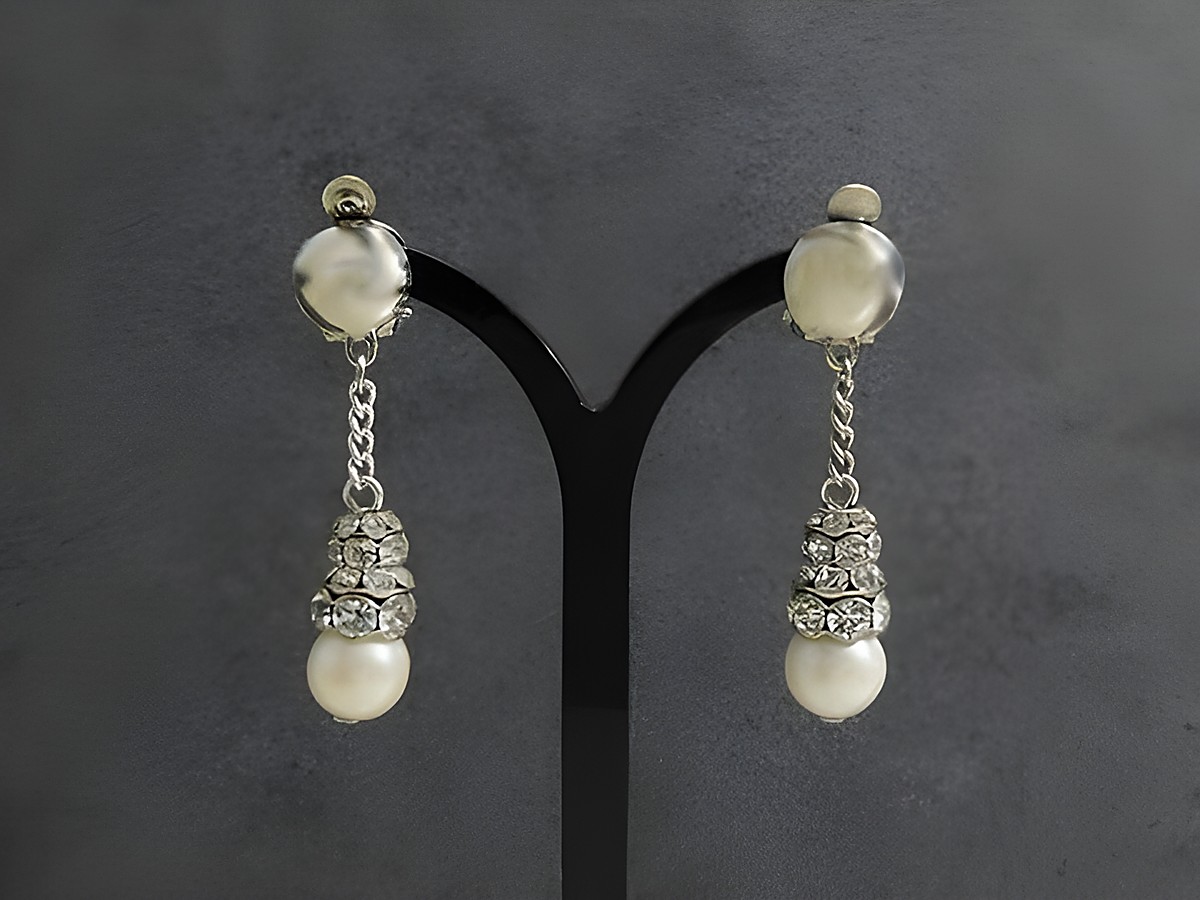 Luxuriöse Strass Ohrclips in Silberfarbe mit weißen Perlen, gefertigt von Juwelier Harnisch, dekorative Ohrhänger mit funkelndem Strass Schmuck.