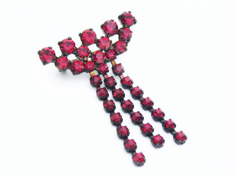 Rote Strass Designer Brosche im Sexy City Look von Juwelier Harnisch, aus leuchtenden roten Strasssteinen in eleganter Anordnung, ideal für einen glamourösen Auftritt.