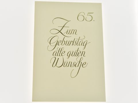 Schlichte Geburtstagskarte mit goldener eleganter Schrift, die zum 65. Geburtstag gratuliert und alle guten Wünsche übermittelt, hergestellt von Juwelier Harnisch.