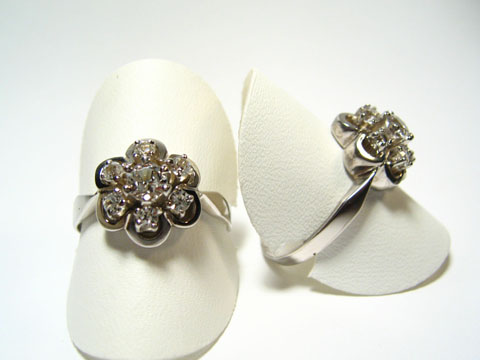 Silber Ring rhodiniert mit weiß gefassten Steinen, Hersteller Juwelier Harnisch, verstellbare Ringe in floraler Form auf weißem Hintergrund.