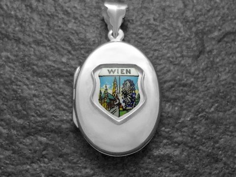 Silbermedaillon von Juwelier Harnisch mit dem Motiv des Stephansdoms und des Riesenrads in Wien, kunstvoll gestaltet, repräsentiert die Sehenswürdigkeiten Österreichs.