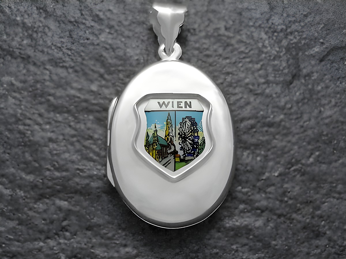 Silbermedaillon von Juwelier Harnisch mit dem Motiv des Stephansdoms und des Riesenrads in Wien, kunstvoll gestaltet, repräsentiert die Sehenswürdigkeiten Österreichs.