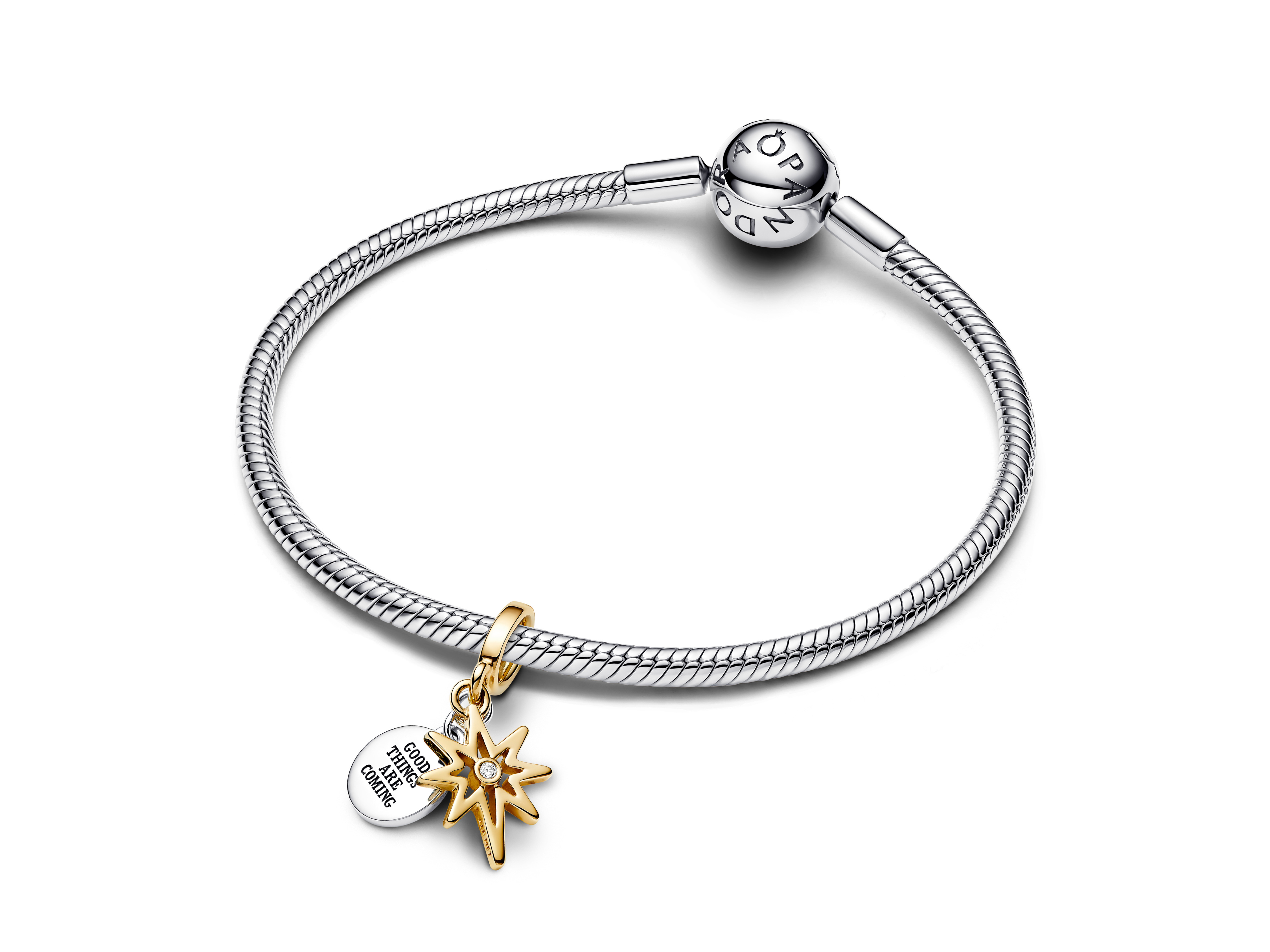 Armband aus Silber mit einem Anhänger in Gelbgold, der einen Sonnenstern mit einem lab-grown Diamanten zeigt. Ein zweiter Anhänger trägt die Aufschrift Good things are coming. Hersteller: Pandora.