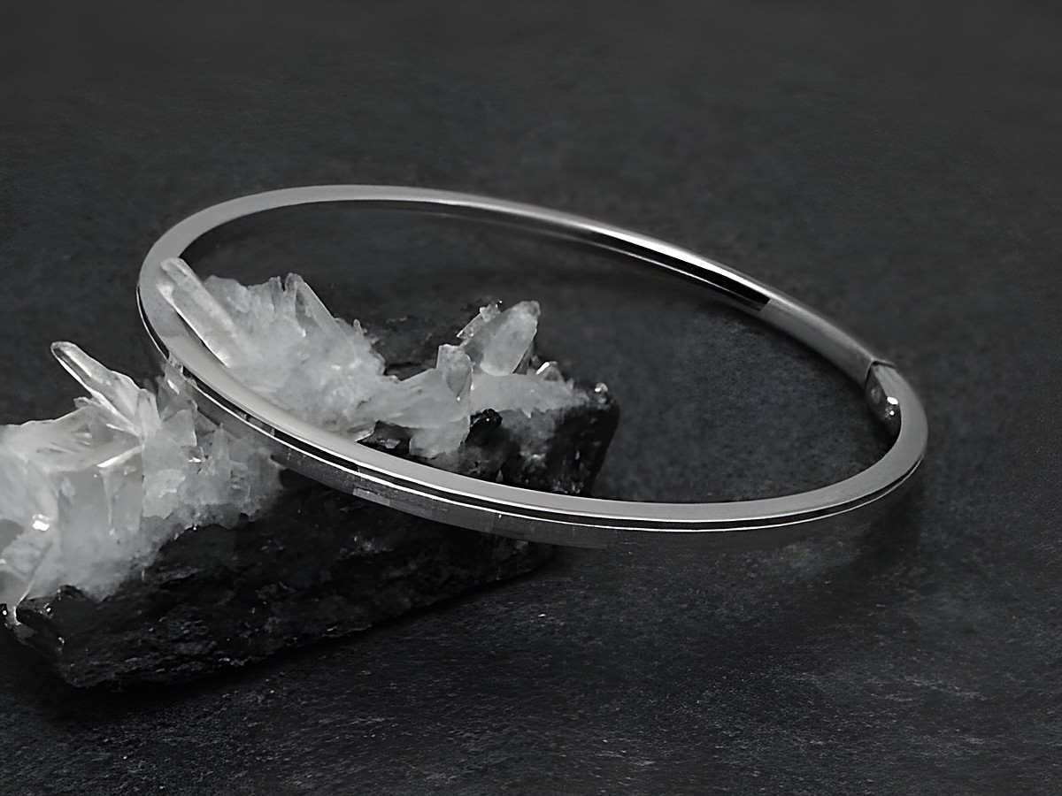 Silber Armreifen im Disco-look mit einer Breite von 2,9 mm, rhodiniert, Länge 18 cm, Hersteller Juwelier Harnisch, elegant auf einem schwarzen Hintergrund präsentiert.