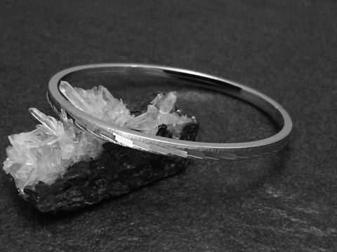 Silber Armreifen schick 4 mm rhodiniert 18 cm Hersteller Juwelier Harnisch auf einer stilvollen Unterlage aus Kristall. Elegantes Design für modische Akzente.