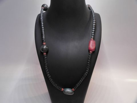 Holzkette Multiform 21 mm bunt 90 cm Holz Schmuck von Juwelier Harnisch auf einer stylischen Schmuckpuppe präsentiert, mit mehreren bunten Holzperlen in verschiedenen Formen und Farben.
