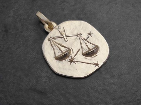 Anhänger in Gold mit dem Sternzeichen Waage, der eine stilisierte Waage und Sterne zeigt, gefertigt vom Juwelier Harnisch. Ideal für Sternzeichenliebhaber.