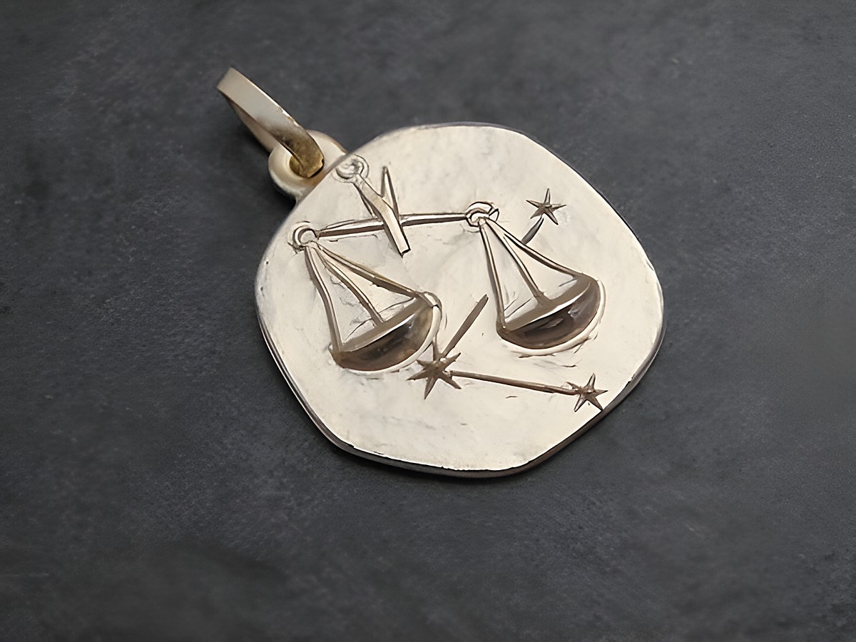 Anhänger in Gold mit dem Sternzeichen Waage, der eine stilisierte Waage und Sterne zeigt, gefertigt vom Juwelier Harnisch. Ideal für Sternzeichenliebhaber.