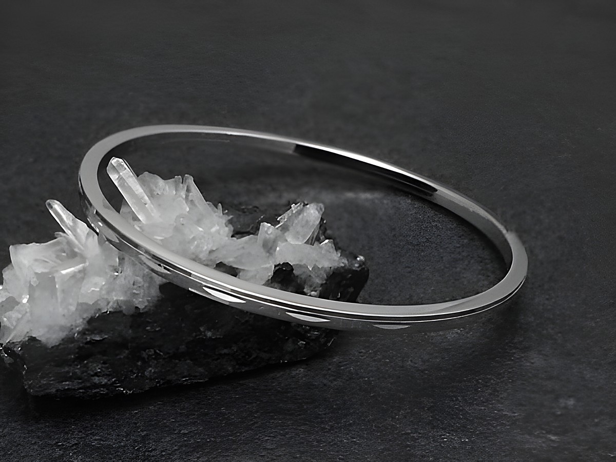 Silber Armreifen zart 3 mm rhodiniert 18 cm von Juwelier Harnisch, elegant auf einem schwarzen Hintergrund dargestellt, mit Kristallen zur Präsentation.